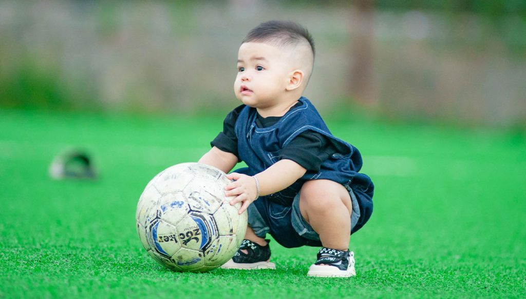 young boy playing with soccer ball