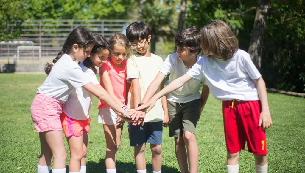 Group of kids enjoying outdoor playtime, displaying teamwork in a sunny park.