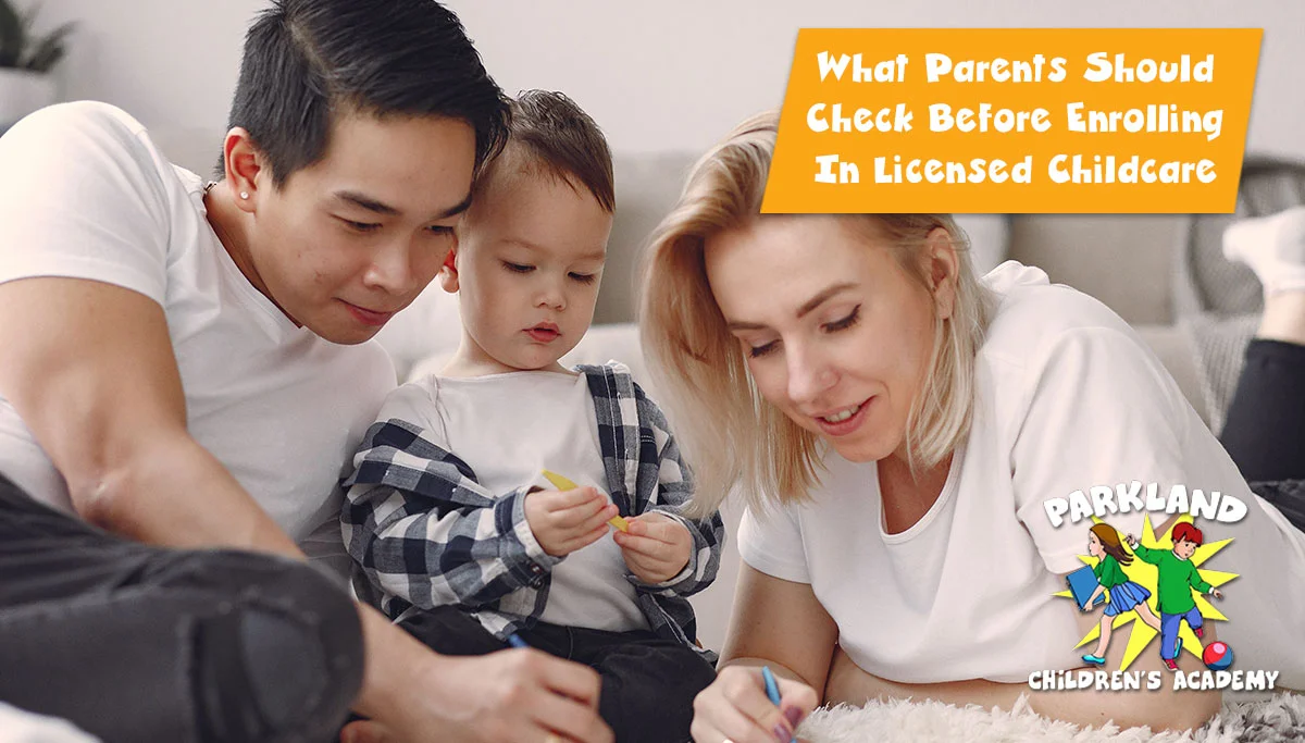 parents sitting on the floor with their small child as he plays with an object