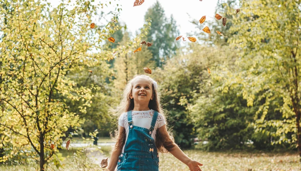 young girl walking through a fall forest